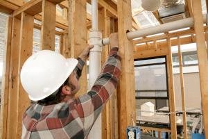 Plumber Installing A Pipe